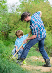 Wall Mural - Little helper in garden. Cute child in nature having fun with cowboy dad. Find treasures. Little boy and father with shovel looking for treasures. Happy childhood. Adventure hunting for treasures