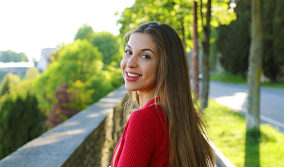 Wall Mural - Gorgeous young woman with long hair turn the head and looking at camera when walking in the street