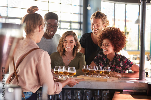Fotomural Waitress Serving Group Of Friends Beer Tasting In Bar