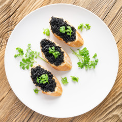 sandwiches with halibut eggs and butter decorated with garden cress in white plate on wooden top