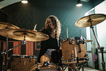 Wall Mural - Woman playing drums during music band rehearsal