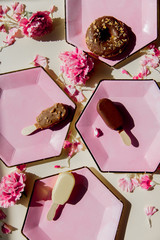 Wall Mural - Donuts and ice-cream on plates with dianthus petals