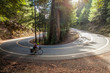 © Mike Butler - Women climbing hairpin turn mountain road on cross country bike.