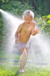 © jordano - little girl playing with a garden sprinkler