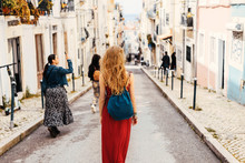Woman In Red Dress Exploring Narrow Streets Of European City Streets