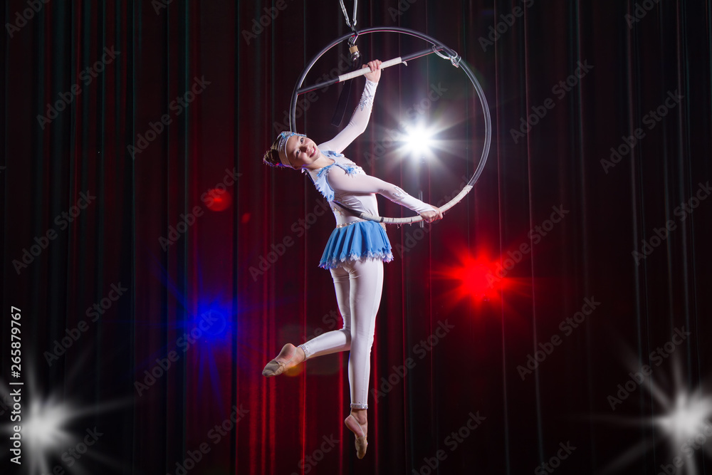 Performs a circus girl actress. Circus aerial gymnast on the hoop ...