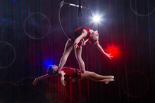 Circus Actress Acrobat Performance. Two Girls Perform Acrobatic Elements In The Air Ring.