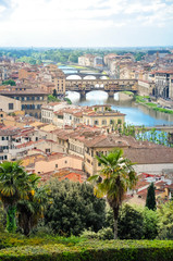 Wall Mural - Ponte Vecchio or Old Bridge is a medieval stone bridge over the Arno River, in Florence, Italy. It's noted for having shops on in. Photos taken right after the rain as the sun was coming out.