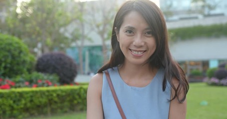 Canvas Print - Woman use of mobile phone and smile at the camera in the park