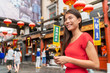 © Maridav - China food market tourist woman walking using phone on Beijing hutong street travel vacation adventure. City lifestyle young Asian girl. Asia summer travel destination. Girl traveling in chinatown.