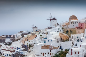  Windmills in the colorful and pictoresque village of Oia on a rare rainy day