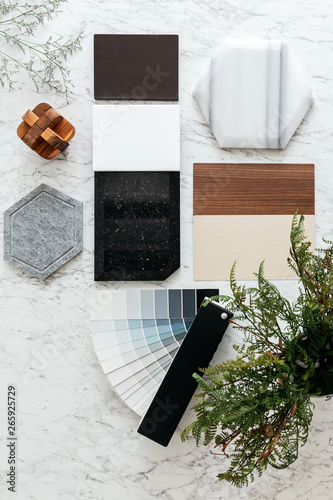 Fotomural Top view of Material Selections including Granite tile, Marble tile, Acoustic tile, Walnut and Ash Wood Laminate and Painted color tone album with plant and flowers on marble top table
