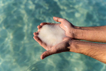 male hands holding salt from the dead sea