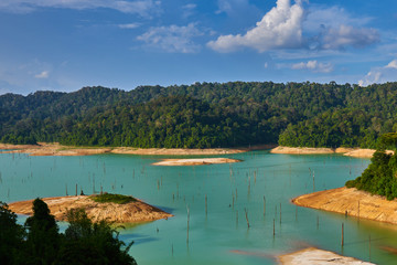 A landscape of Kenyir Lake, Terengganu, Malaysia. Dead woods, turquoise water and lush green tropical rainforest. Ecological tourism.