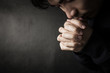 © christianchan - Praying Man Against Dark Background With Copy Space