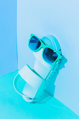 Wall Mural - Fashionable art set with plastic sandals and sunglasses in pastel cyan and serenity duotone colors.