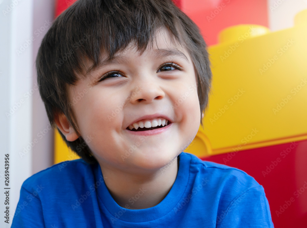 Portrait of adorable kid looking out with smiling face, Head shot mixed ...