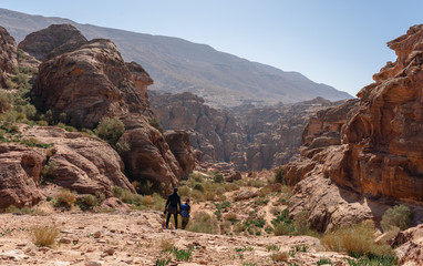 Wall Mural - travelers with backpack hiking in petra the rose city in jordan, middle east. travel lifestyle and a