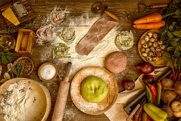 Wall Mural - Fresh homemade pasta with pasta ingredients on the dark wooden table top view. Italian pasta tagliatelle on a dark wooden table. Colored raw vegetable pasta with beets, carrots and spinach.