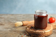 Composition with jar of barbecue sauce on wooden table. Space for text