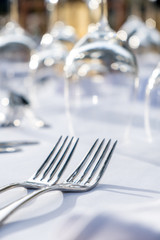 Elegant table setting: white plates with white linen and silverware. Weddingor festive dinner table set up