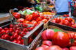 © eskstock - Farmers' food market stall with variety of organic vegetable. Vendor serving and chating with customers.