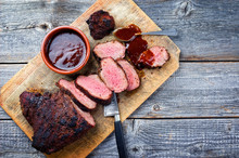 Barbecue Dry Aged Wagyu Tri Tip Steak With BBQ Sauce As Dip As Top View On A Wooden Cutting Board With Copy Space