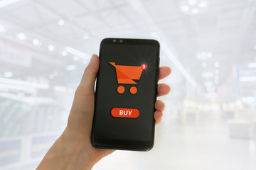 Hand holding mobile smart phone with my shopping carts screen on Supermarket blur background