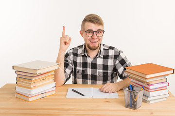 People, knowledge and education concept - Smart student sitting at the table with books and notebook