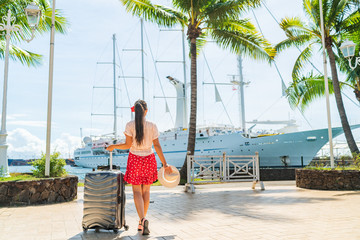 Cruise travel passenger going on board embarking ship with luggage suitcase. Woman tourist on Tahiti French Polynesia summer vacation.