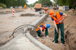© Photographee.eu - Two workers in orange safety jacket on a road construction, industry and teamwork