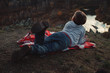 © olga_polyanskaya - The child lies on a red blanket in the mountains and looks at the sky