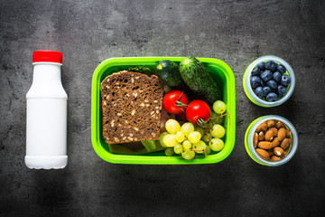 Wall Mural - Lunch box with sandwich, vegetables, banana, yogurt, nuts and ber