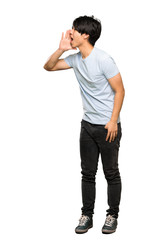 Wall Mural - A full-length shot of a Asian man with blue shirt shouting with mouth wide open to the lateral over isolated white background