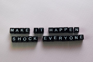 Make it happen shock everyone on wooden blocks. Motivation and inspiration concept