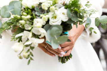 Wall Mural - Exquisite bridal bouquet of white flowers in the hands of an unrecognizable bride