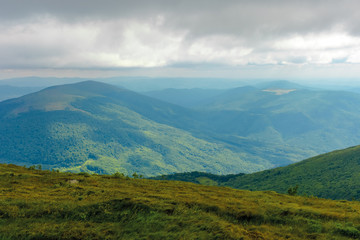 sun lit valley in afternoon. beautiful mountainous landscape and cloudy sky in golden light. lovely scenery after the storm. view from the top of a hill