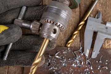 Drilling with a metal drill. Small locksmith work in the home workshop.