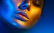 © Subbotina Anna - Fashion model woman face in bright sparkles, colorful neon lights, beautiful sexy girl lips. Trendy glowing gold skin make-up. Glitter metallic shine makeup