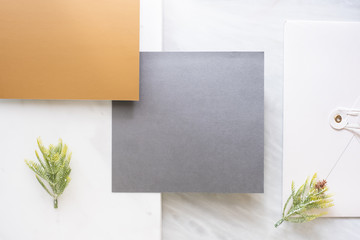 Poster - Top view of blank grey card overlap on envelop and gold card with pine leaf on two layer step of marble table top.Mock up template for display of design .luxury business items