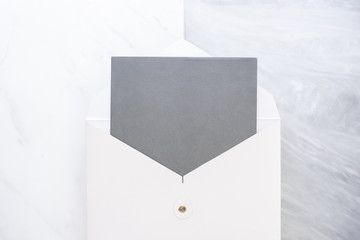 Poster - Top view of blank grey card in white envelop on two layer step of marble table top.Mock up template for display of design.business items.