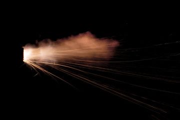 Wall Mural - Texture of firearm shot with bright flash of light, sparks, smoke and gunpowder gases on black background