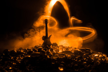 Wall Mural - Music concept. Acoustic guitar isolated on a dark background under beam of light with smoke with copy space. Guitar Strings, close up. Selective focus. Fire effects. Surreal guitar