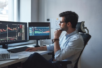 busy working day. side view of successful trader or businessman in formal wear and eyeglasses workin