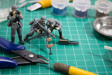 Painting Plastic Model WW2 German Soldier And Tools On Cutting Pad.	