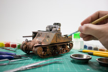 Painting Plastic Model WW2 Tank M3 Lee With Part And Tools On Wooden Workbench Closeup.	