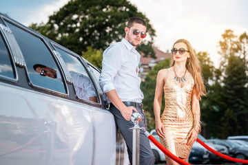 Wall Mural - Woman and man leaning against a limo car