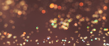 Beautiful Gold Bokeh On A Brown Background.