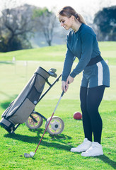 Wall Mural - woman preparing to hit ball at golf course