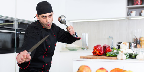 Wall Mural - Portrait of the man proffesional who is posing with devices in the kitchen